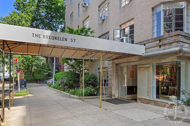 entrance to property featuring cooling unit and brick siding