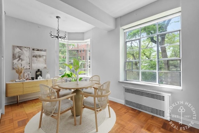 dining space with radiator, an inviting chandelier, and baseboards