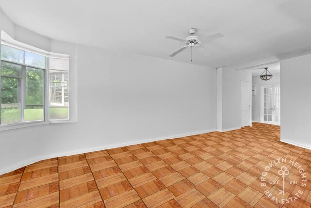 empty room with a ceiling fan and baseboards