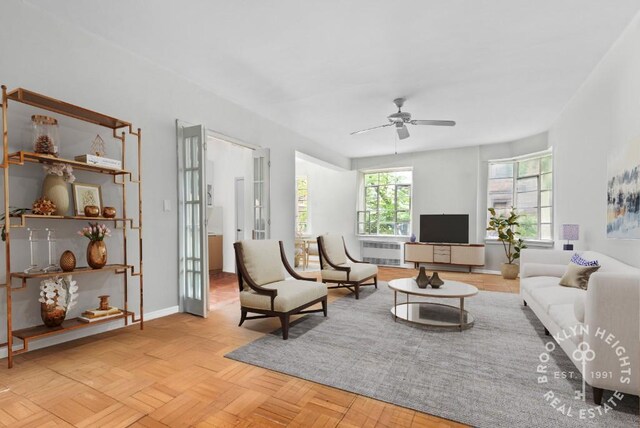 living area featuring ceiling fan and baseboards