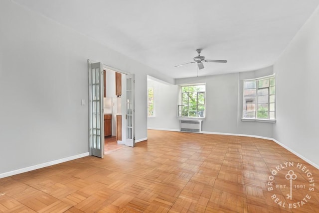 unfurnished room featuring radiator heating unit, ceiling fan, and baseboards