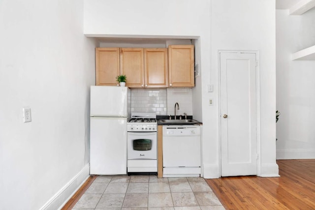 kitchen featuring sink, backsplash, light brown cabinets, white appliances, and light hardwood / wood-style flooring