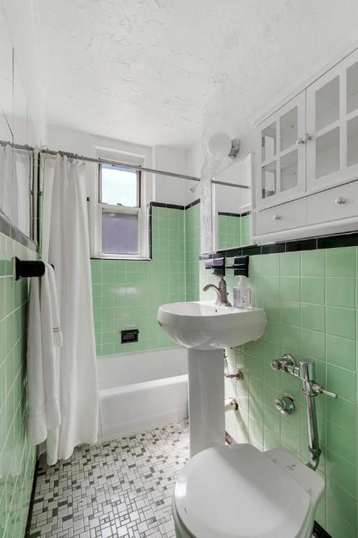 bathroom featuring toilet, tile walls, and shower / bath combo