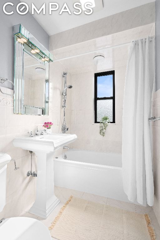 bathroom featuring toilet, tile patterned flooring, tile walls, and shower / bath combo