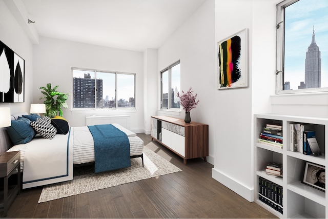 bedroom with baseboards, dark wood finished floors, and a city view