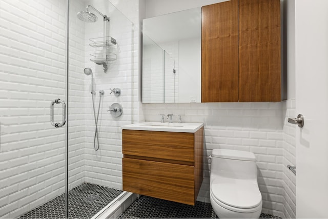 bathroom with tile walls, toilet, and a stall shower