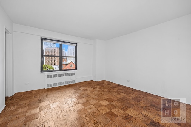 empty room with radiator heating unit and parquet floors