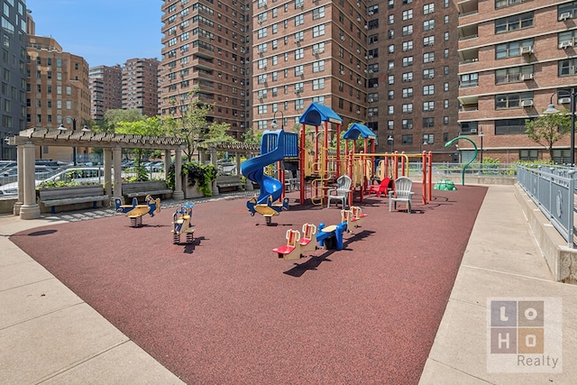 community jungle gym featuring a city view, fence, and a pergola