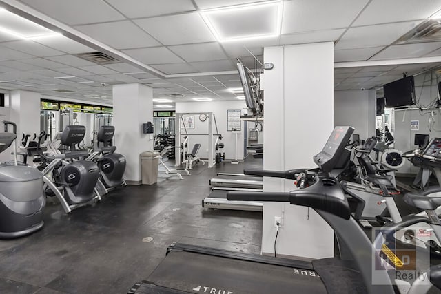 exercise room with a paneled ceiling and visible vents