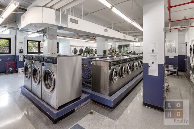 community laundry room featuring stacked washer and clothes dryer, visible vents, and washer and clothes dryer