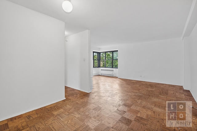 unfurnished room featuring radiator heating unit