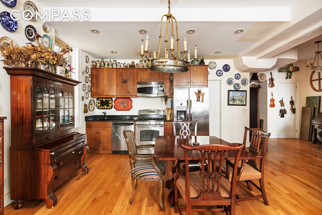 dining area featuring a notable chandelier and light wood-style flooring