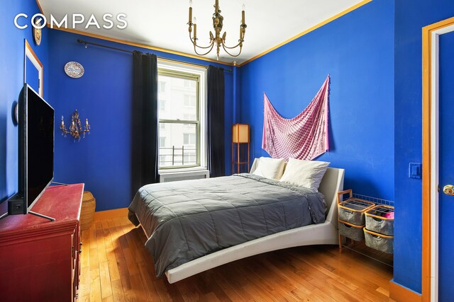 bedroom featuring a notable chandelier and wood-type flooring