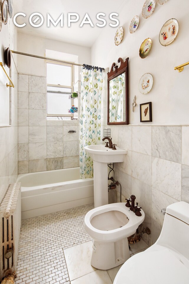 full bath featuring shower / tub combo, toilet, radiator heating unit, a bidet, and tile walls