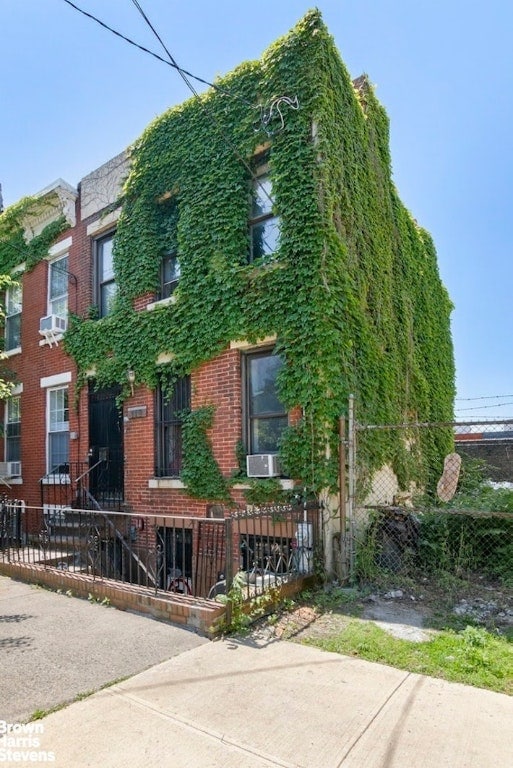 view of front of property with brick siding and fence