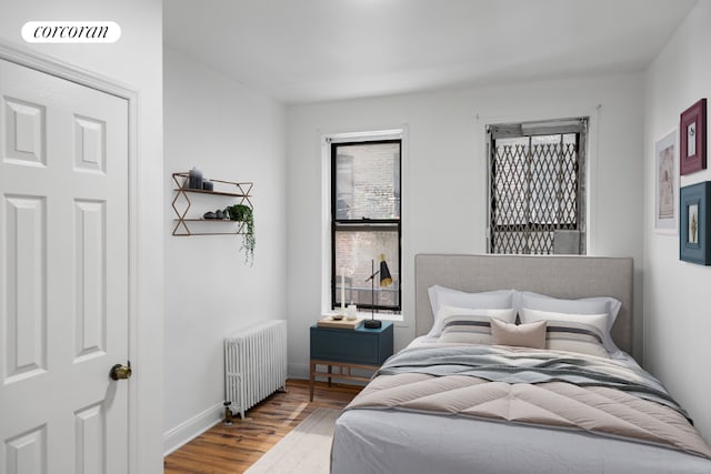 bedroom with hardwood / wood-style flooring and radiator