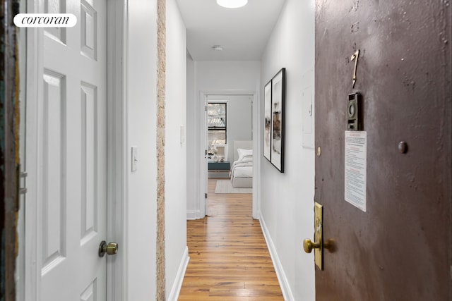 hallway with light hardwood / wood-style floors