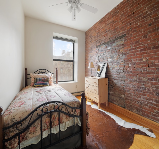 bedroom featuring ceiling fan, a baseboard radiator, wood finished floors, and brick wall