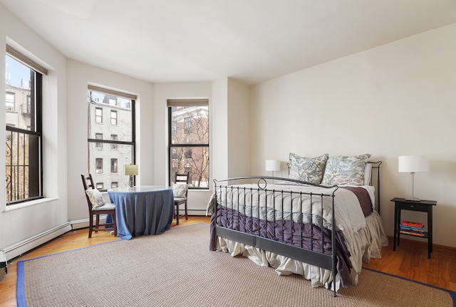 bedroom with baseboards and wood finished floors