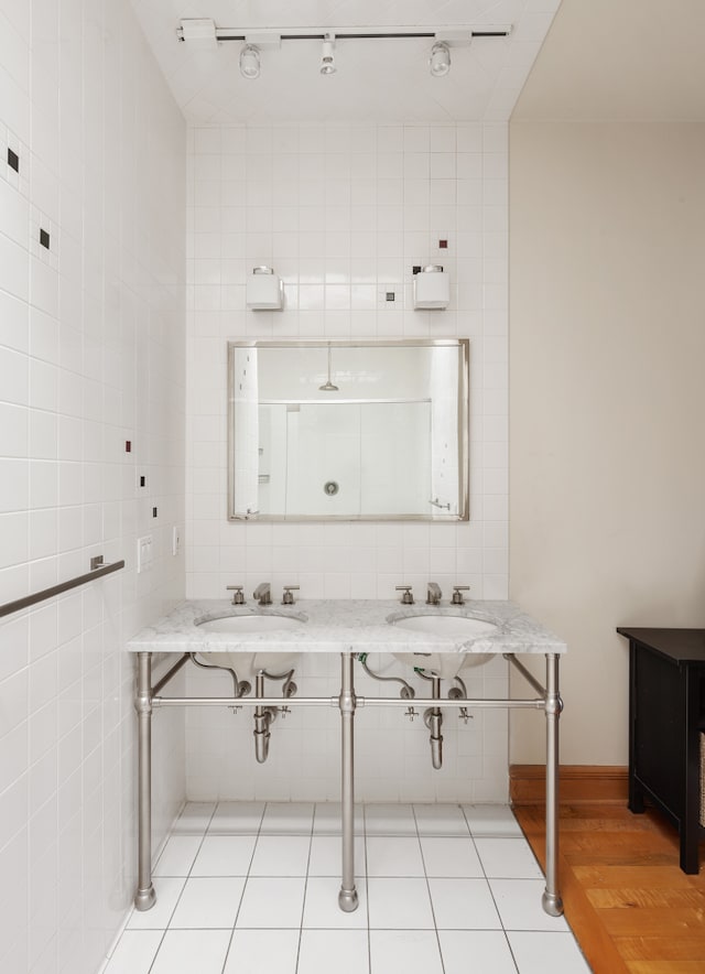 bathroom with tile walls, tasteful backsplash, tile patterned floors, and a sink