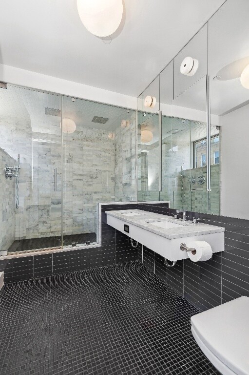 bathroom featuring vanity, tiled shower, and tile patterned floors