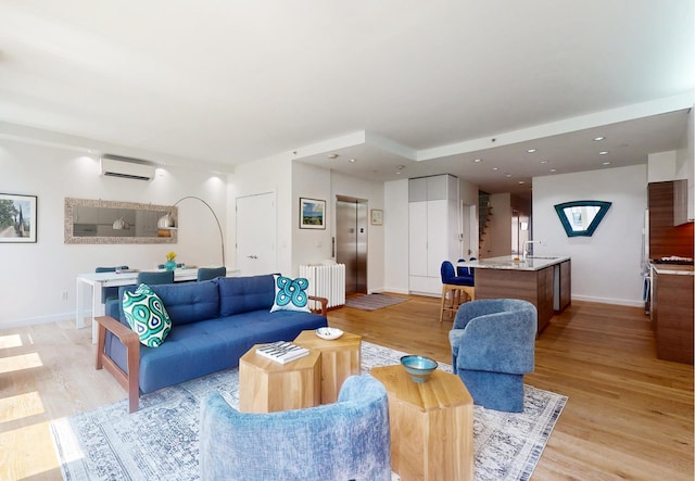 living area featuring radiator, baseboards, an AC wall unit, elevator, and light wood-style floors