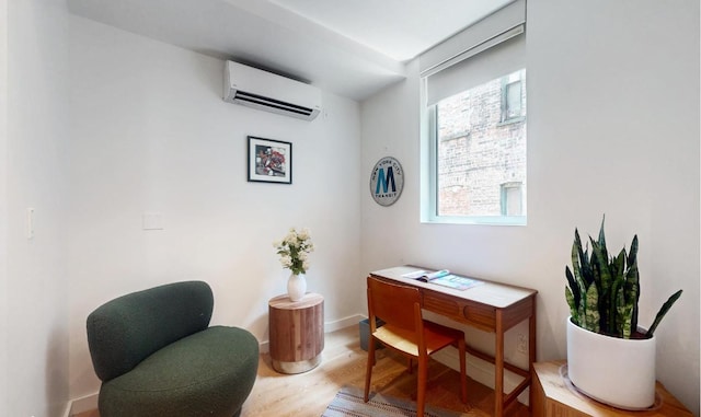 home office with a wall mounted AC and hardwood / wood-style floors