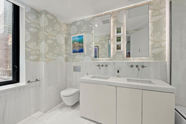 bathroom with tile walls, vanity, and toilet