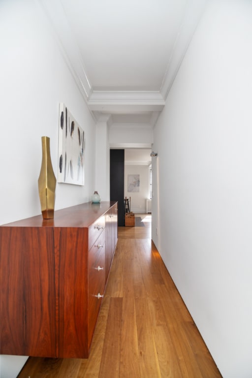 corridor with crown molding and light wood-type flooring