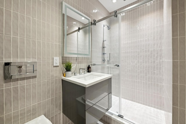 full bathroom featuring vanity, tile walls, and a stall shower