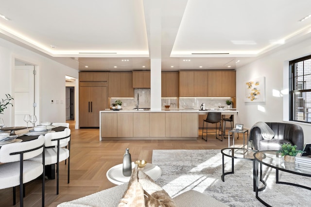 living area with a raised ceiling and recessed lighting