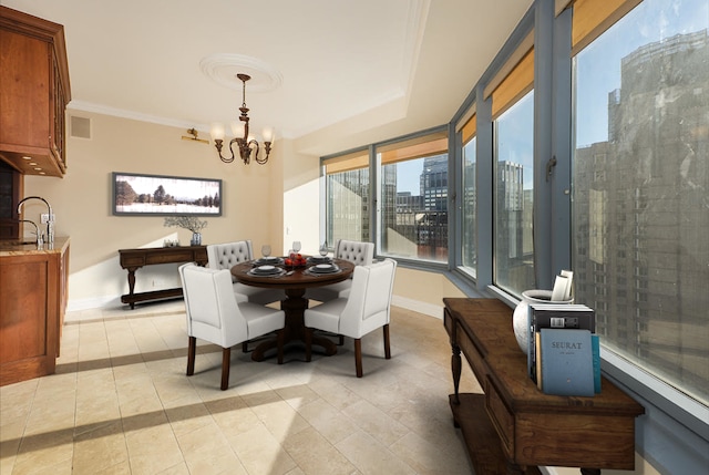 dining room featuring visible vents, baseboards, ornamental molding, a view of city, and an inviting chandelier