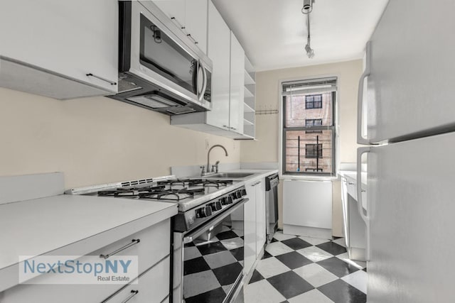 kitchen with white cabinetry, sink, stainless steel appliances, and rail lighting