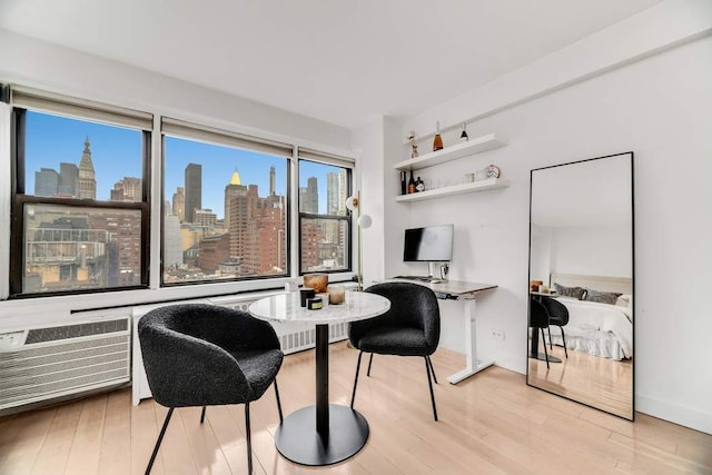 office space featuring a wall unit AC and light hardwood / wood-style flooring