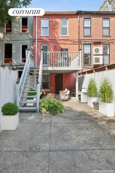 rear view of property featuring stairway and brick siding