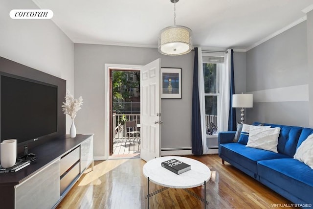 living room featuring a baseboard heating unit, visible vents, plenty of natural light, and wood finished floors