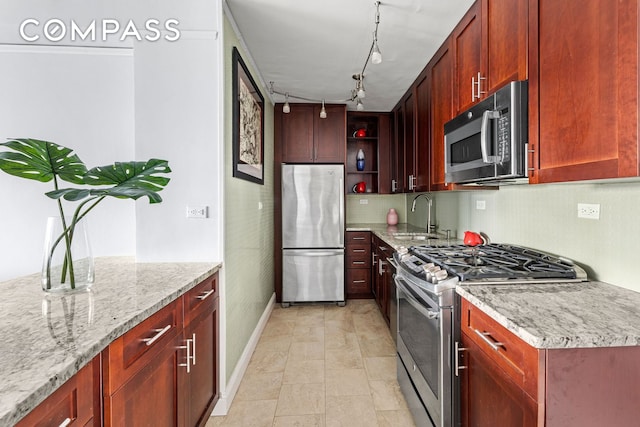 kitchen with stainless steel appliances, a sink, baseboards, open shelves, and light stone counters