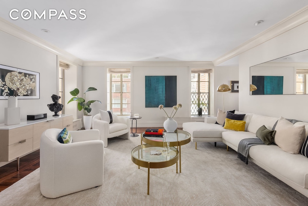 living room with a wealth of natural light, wood finished floors, and ornamental molding