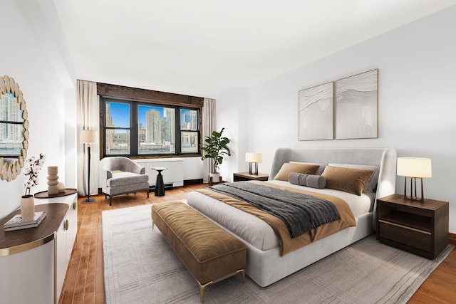 bedroom featuring a view of city and wood finished floors