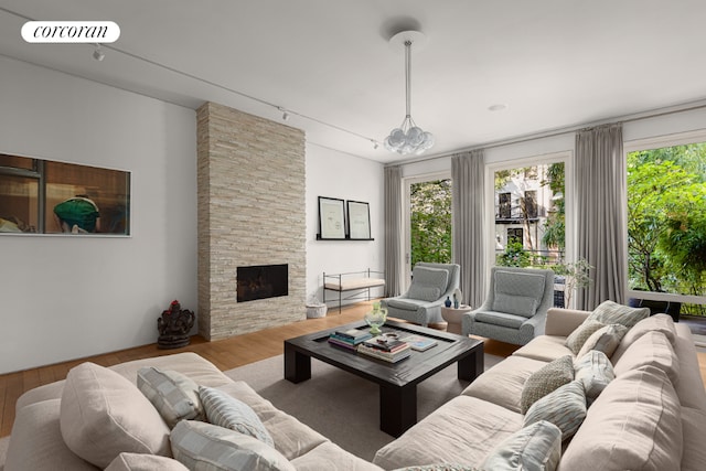 living area with plenty of natural light, visible vents, a fireplace, and wood finished floors