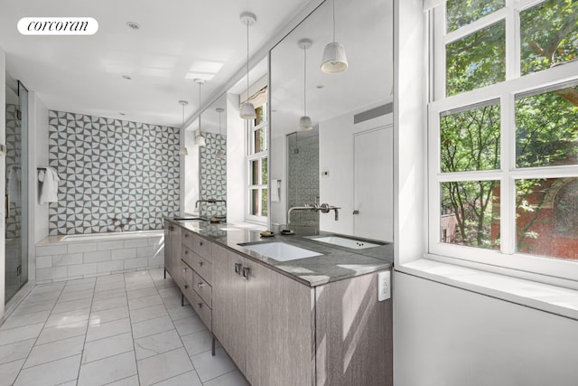 full bathroom featuring a wealth of natural light, a stall shower, a sink, and visible vents