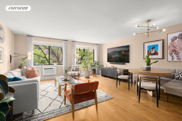 living room with a notable chandelier, light wood-style flooring, visible vents, and a healthy amount of sunlight