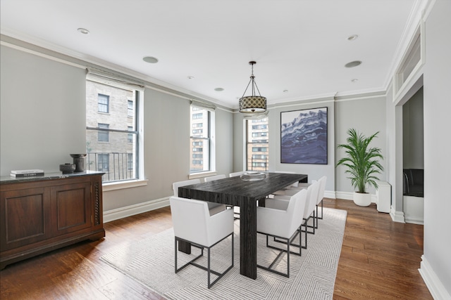 dining space with ornamental molding and dark hardwood / wood-style floors