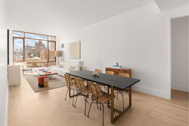 dining space featuring light parquet flooring and a wall of windows