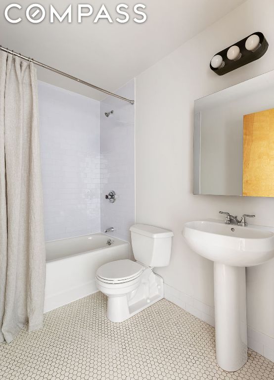 full bathroom featuring sink, shower / bath combo, tile patterned floors, and toilet