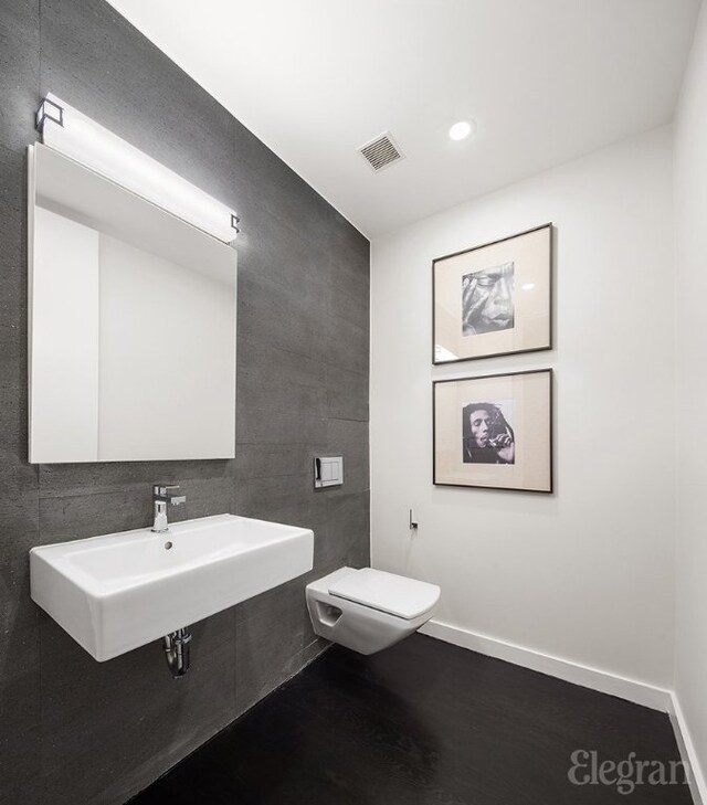 bathroom featuring plus walk in shower, vanity, and tile walls