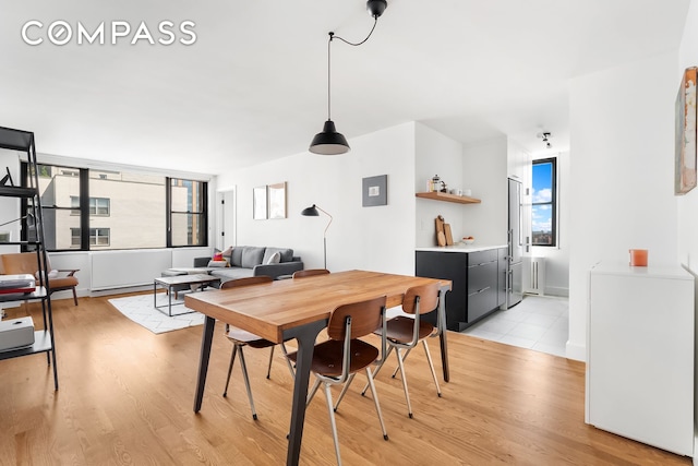 dining room featuring radiator heating unit and light wood-style floors