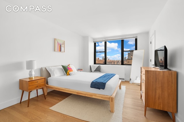 bedroom with light wood-style flooring and baseboards