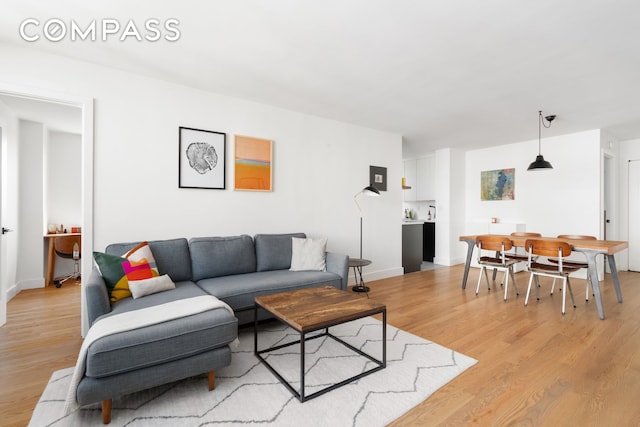 living area featuring baseboards and light wood-style floors