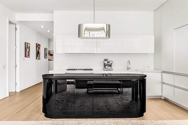 kitchen featuring sink, white cabinets, and light wood-type flooring